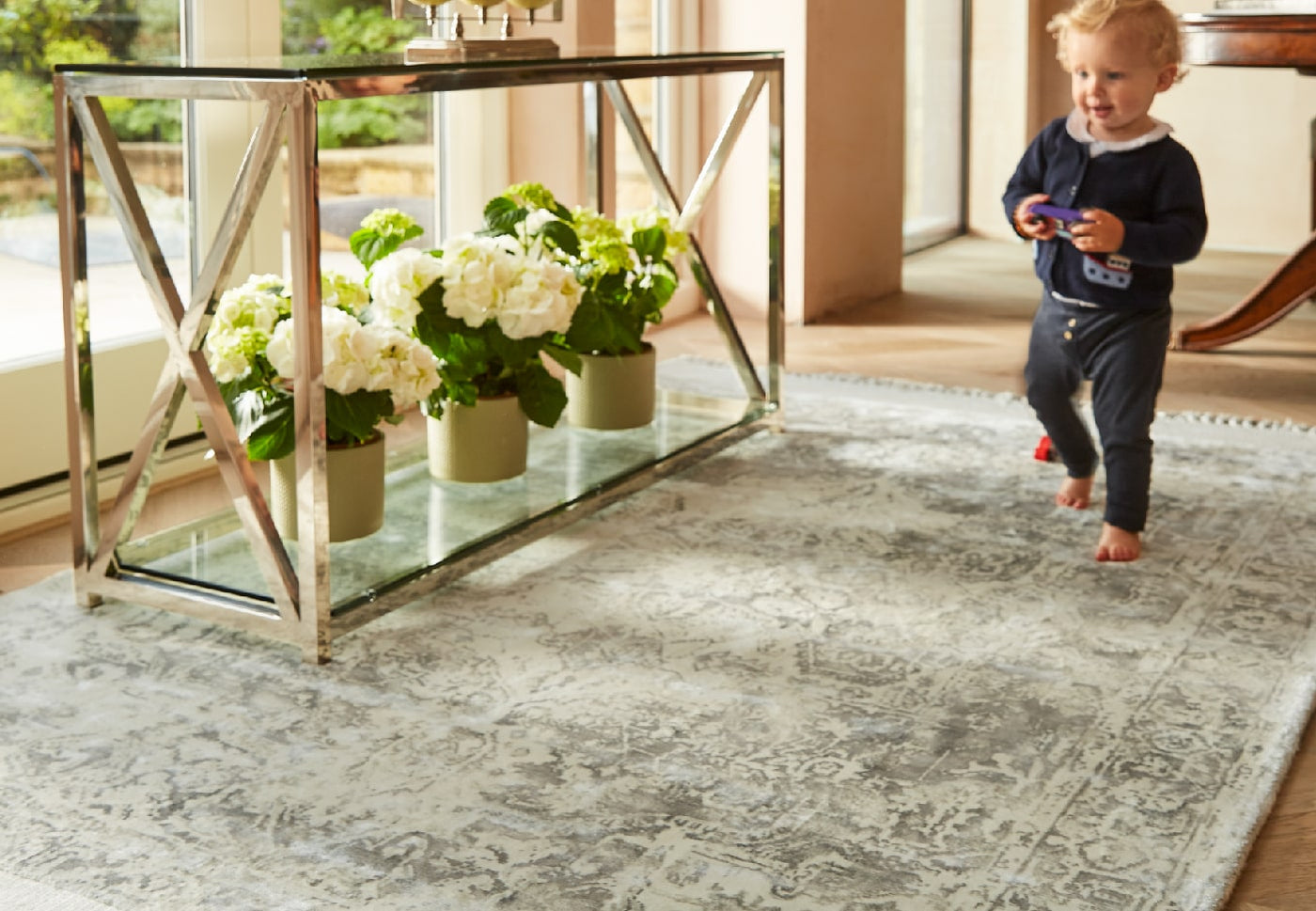 a young child walking across a vintage style rug