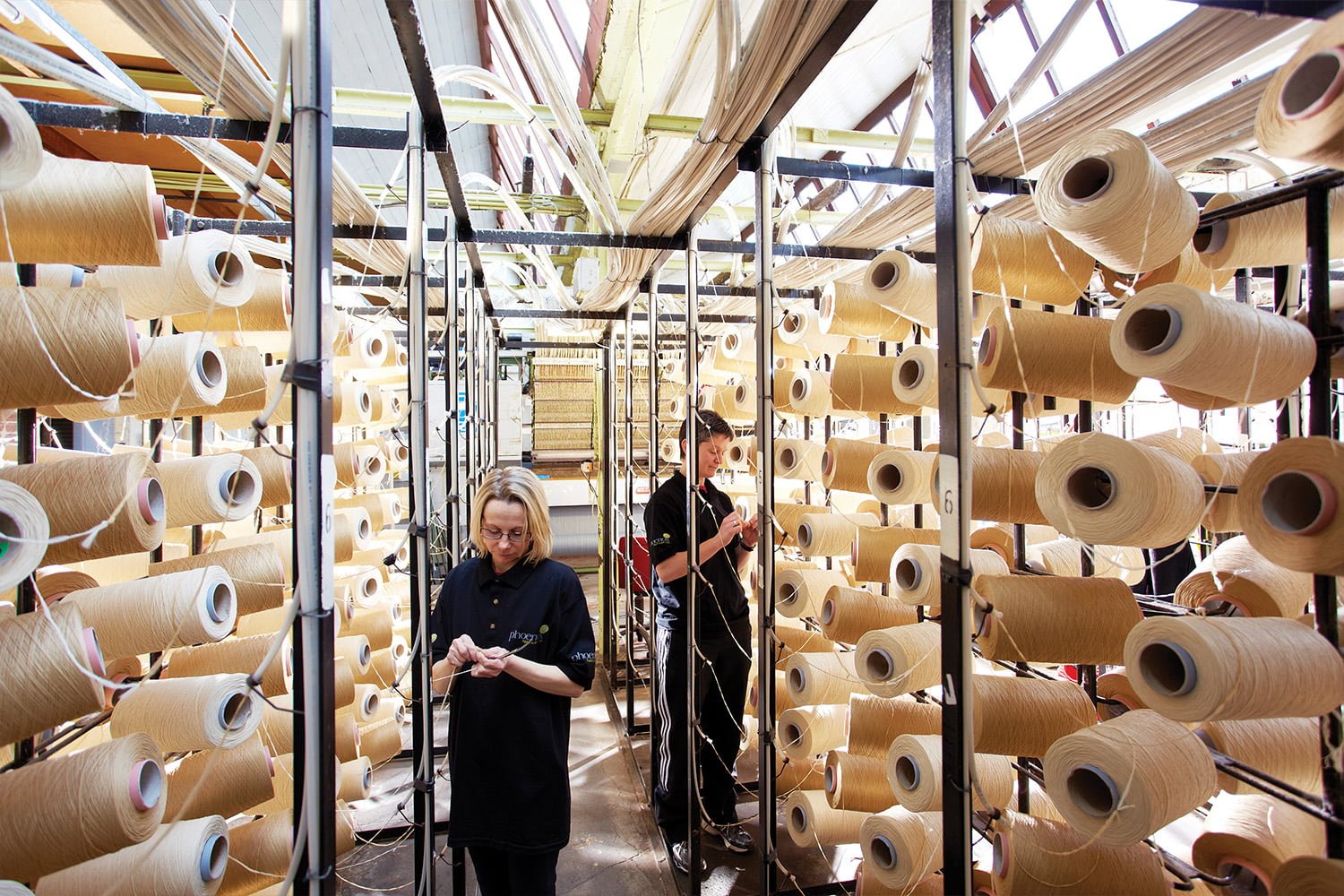 People sorting out racks of wool at Phoenox Textiles