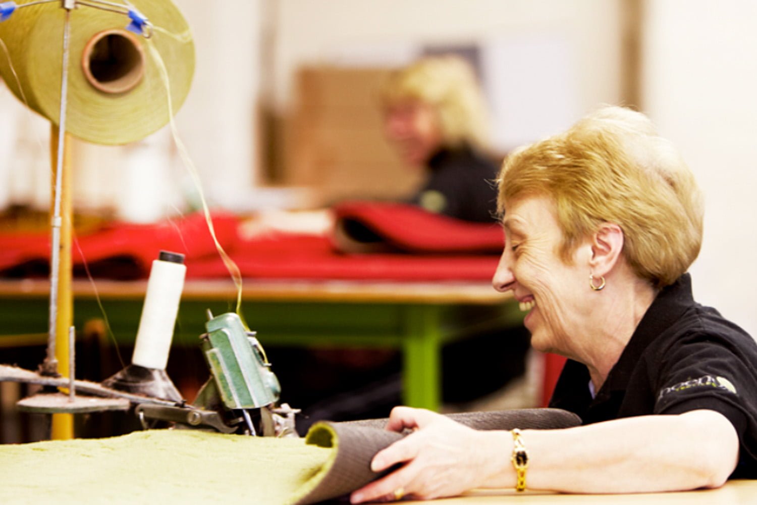 Factory worker at Phoenox Textiles sewing a doormat