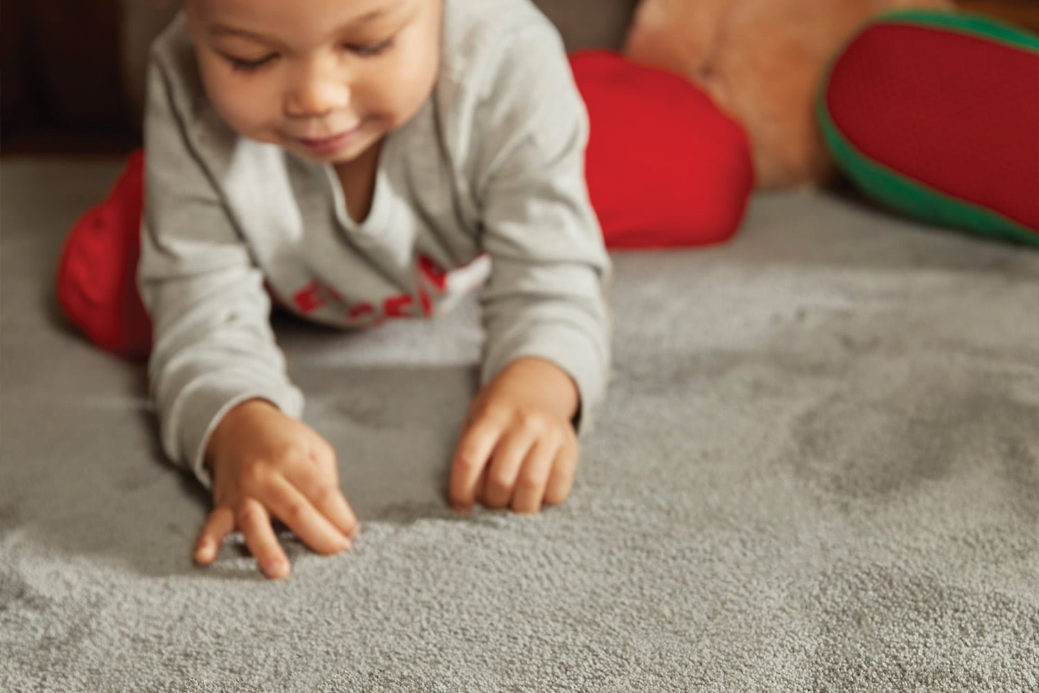 Young child crawling across a rug with noise reducing patent