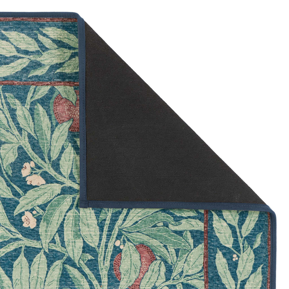 Close-up of Sanderson By Highgrove x Hug Rug Eco-Washable Ancient Apple Tree Midnight with an apple tree design showing rubber backing.