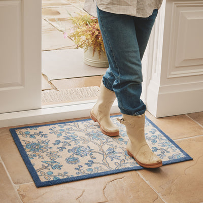 Sanderson By Highgrove x Hug Rug Azalea Walk Wedgwood with a blue floral design, styled on tiled floor. 
