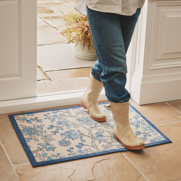 Sanderson By Highgrove x Hug Rug Azalea Walk Wedgwood with a blue floral design, styled on tiled floor. 