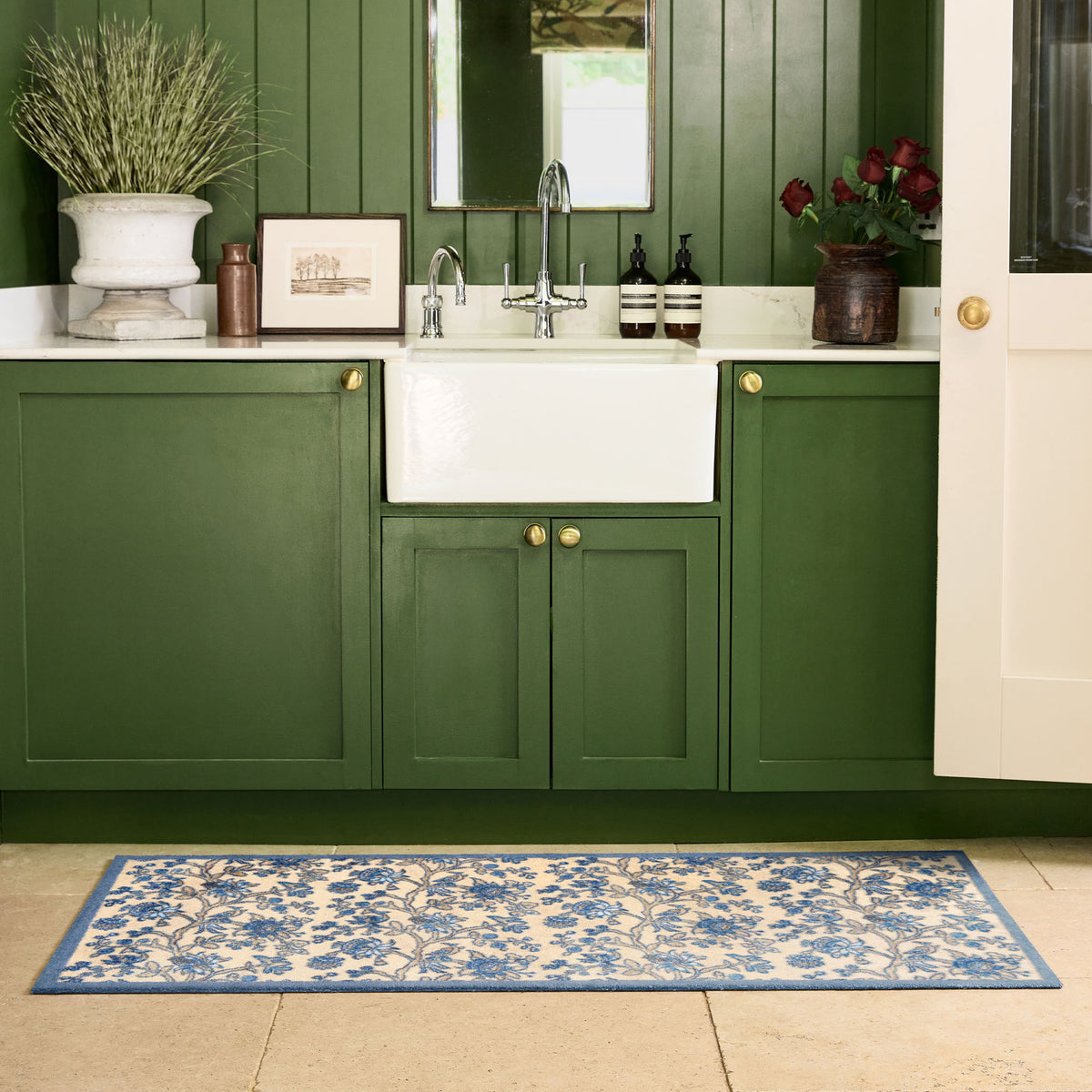 Sanderson By Highgrove x Hug Rug Azalea Walk Wedgwood with a blue floral design, styled by the sink. 