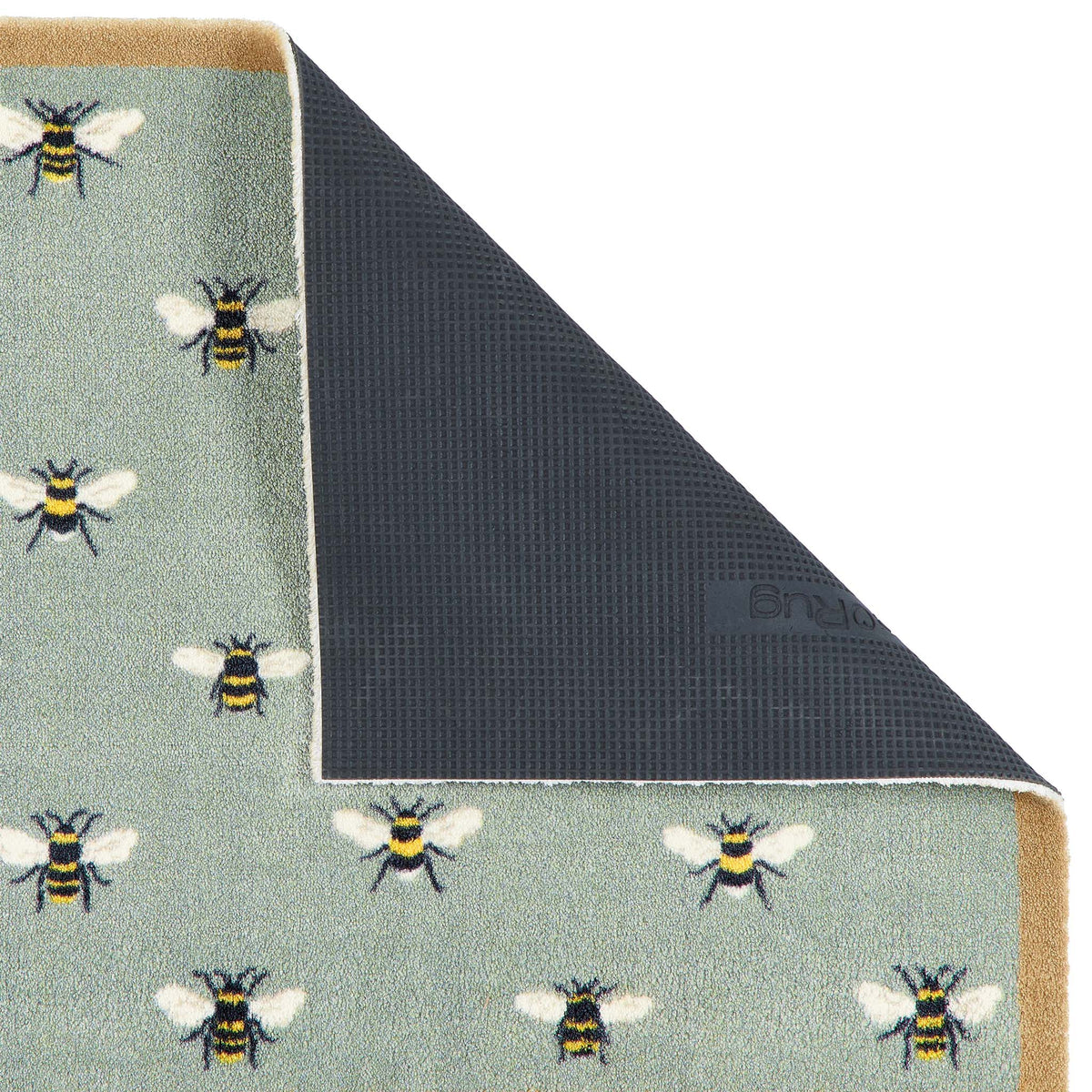 A close-up of a rug corner with the top-left section folded back to show the backing. The visible top surface has a pale sage green base with a repeating pattern of bumblebees in black, yellow, and white.