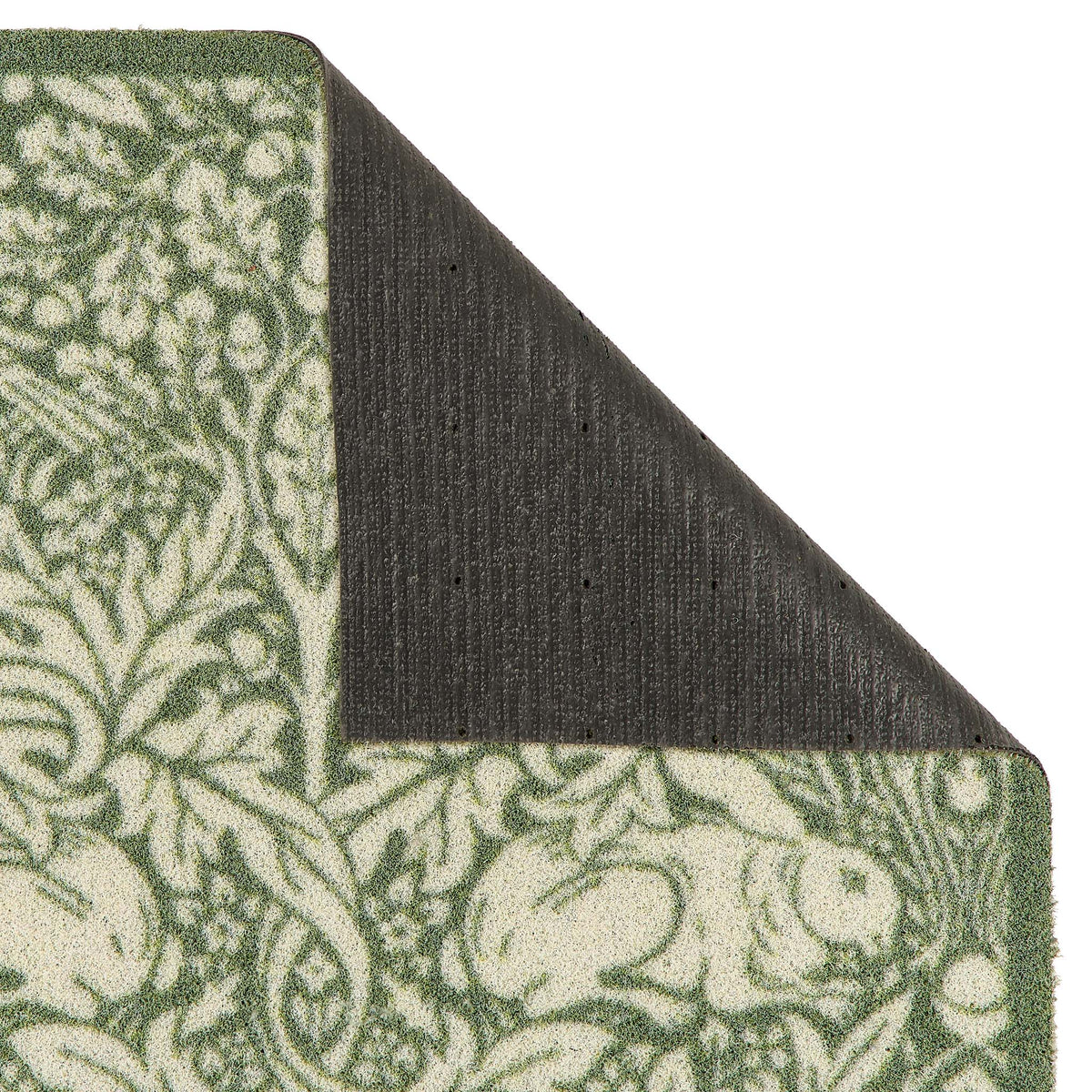 Close-up of a folded outdoor doormat showing a green and cream floral pattern on the top and side, with a dark charcoal backing visible on the underside against a white background.