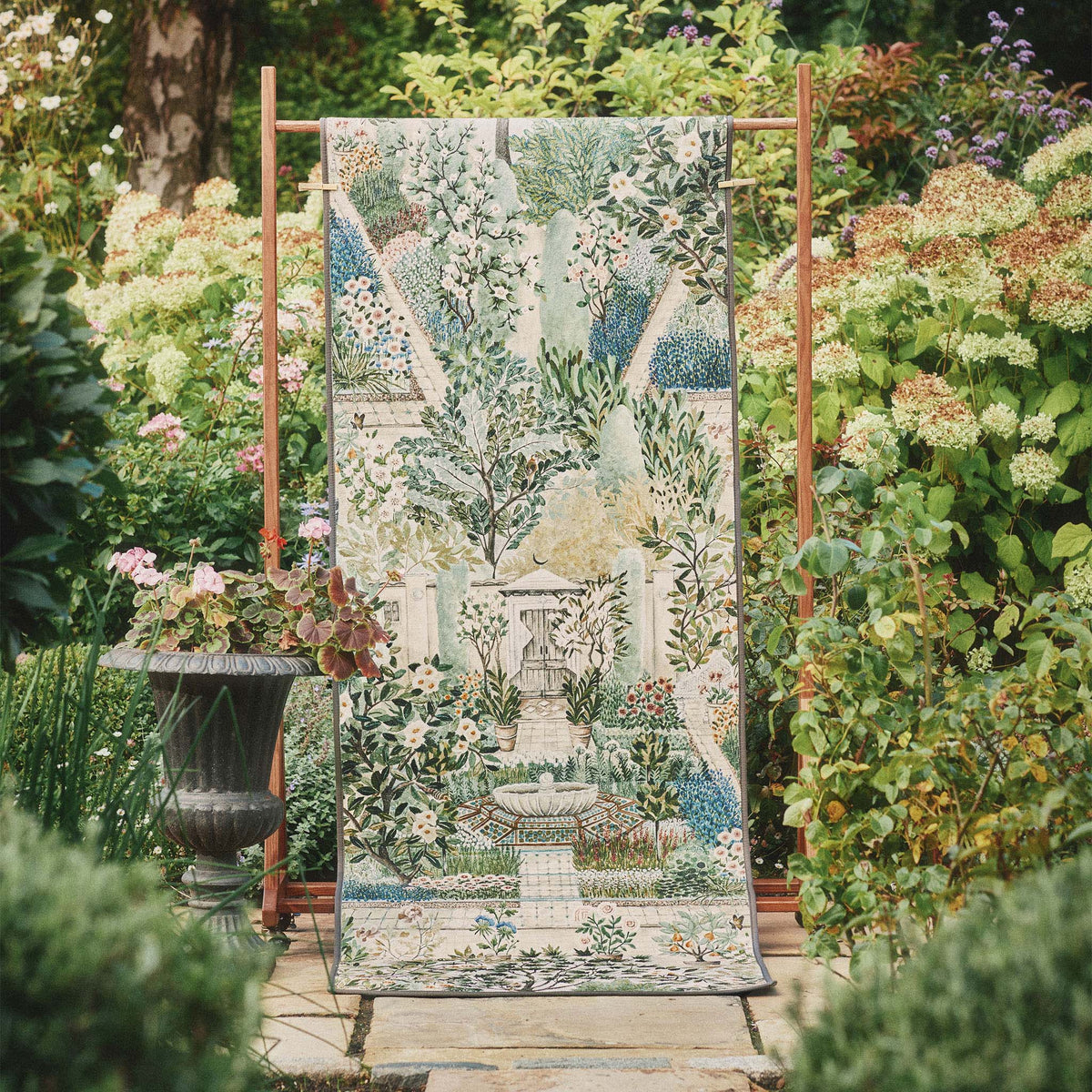 Sanderson By Highgrove x Hug Rug Eco-Washable Carpet Garden Sanctuary Runner with a nature inspired pattern, styled in a garden.