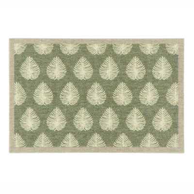 A rectangular doormat with a sage green background and a repeating pattern of cream leaf motifs, finished with a light beige border.