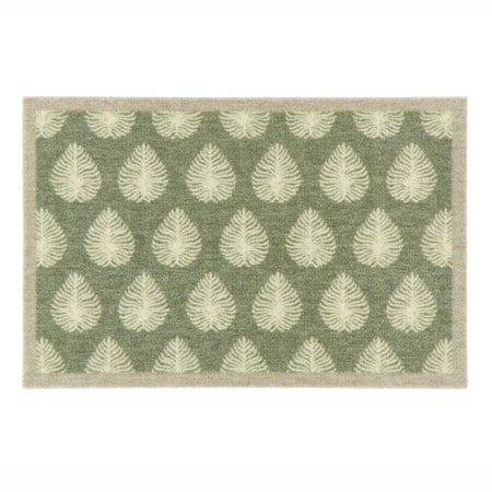 A rectangular doormat with a sage green background and a repeating pattern of cream leaf motifs, finished with a light beige border.