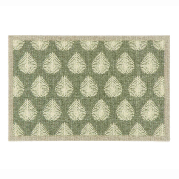 A rectangular doormat with a sage green background and a repeating pattern of cream leaf motifs, finished with a light beige border.