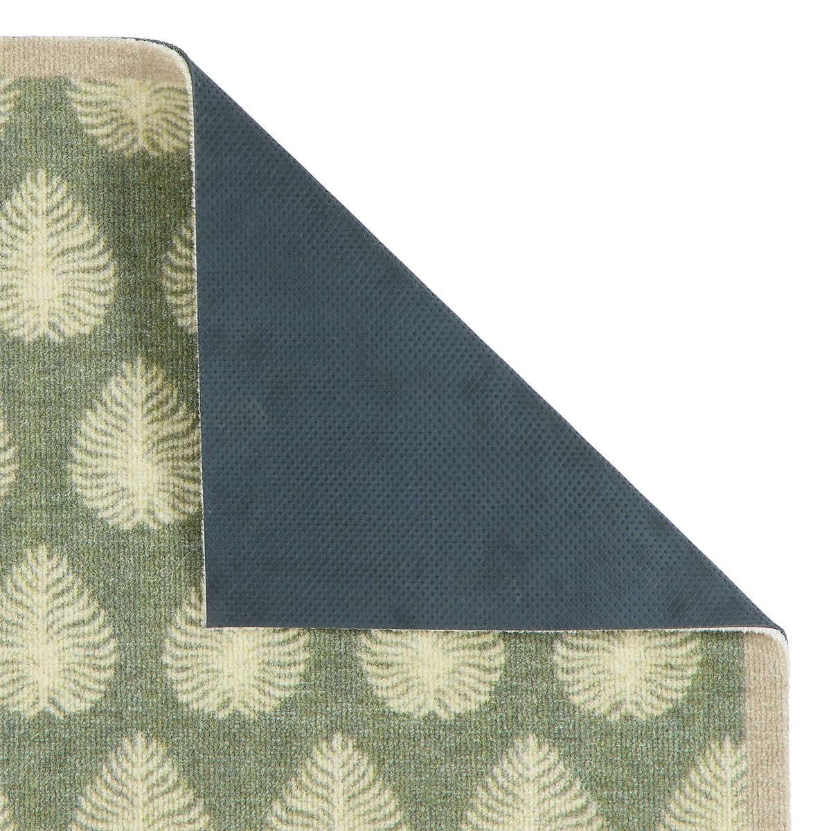 A close-up of a folded doormat showing a sage green top with a cream leaf pattern and a dark charcoal gray textured underside, set against a plain white background.