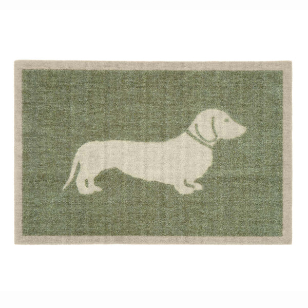 A rectangular doormat with a sage green textured background and a cream-colored silhouette of a dachshund dog, bordered by a cream edge.