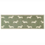 A rectangular runner with a sage green background and a repeating pattern of cream dachshund dogs, finished with a beige woven border.