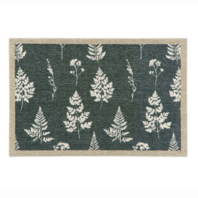 A rectangular doormat with a dark green background featuring a repeating pattern of white ferns and a natural beige textured border.