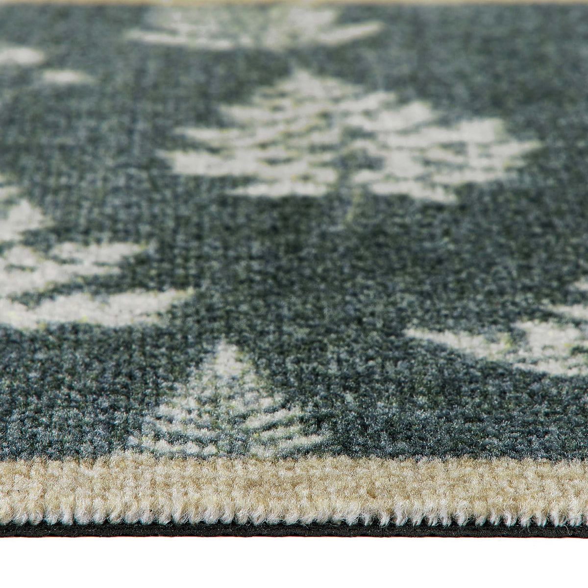 Close-up of a textured area runner showing a dark green background with a repeating light beige pine tree pattern and a beige stitched border.