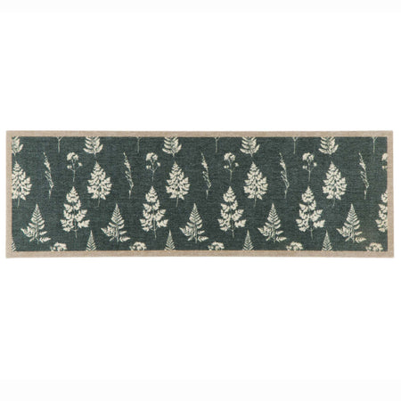 A rectangular runner with a green background featuring a repeating pattern of cream-colored pine trees and a natural tan border.