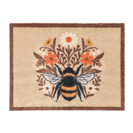 A rectangular doormat with a natural beige background, a dark brown border, and a central bumblebee motif surrounded by orange, white, and yellow flowers.
