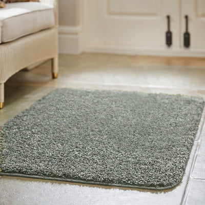 Howler and scratch shaggy green fleck rug with a green shaggy pile, styled on tiled floor.