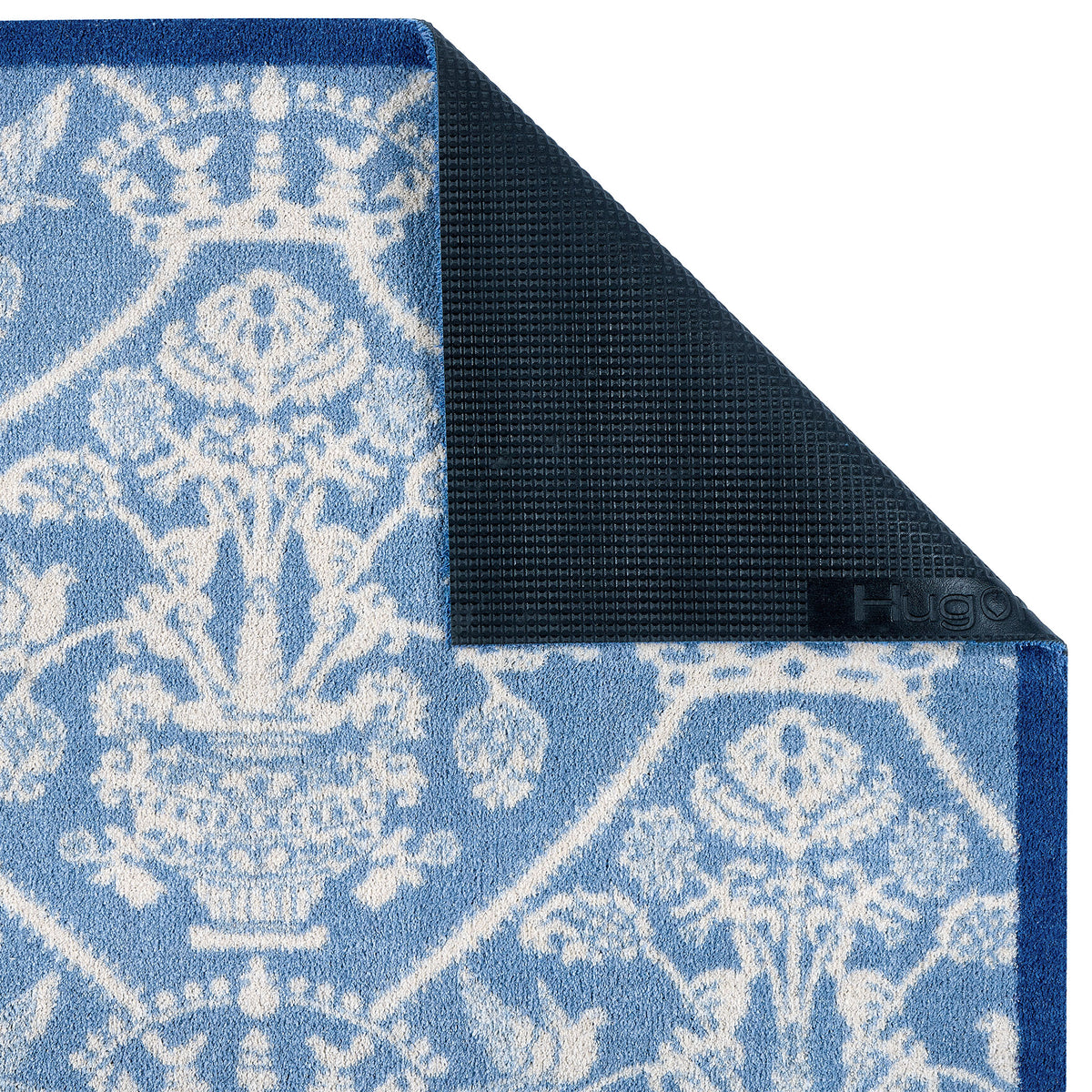 Sanderson By Highgrove x Hug Rug Highgrove Damask Tetbury Blue with a traditional style pattern showing the rubber backing.