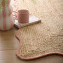 Jute Scalloped Edge Peach Rug- A jute rug with a pink wool wipped edge border.
