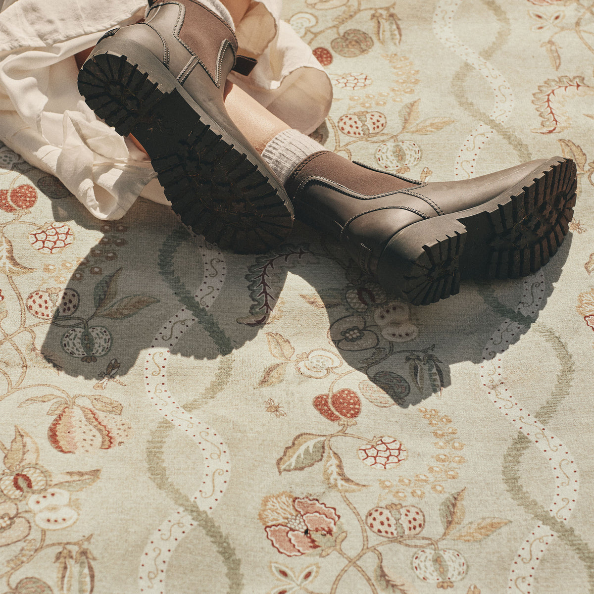 Close-up of Sanderson By Highgrove x Hug Rug Eco-Washable Kitchen Garden Olive & Russet with a floral design. 