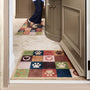 Hug Rug Tartan Paw Green Doormat with a check pattern with hearts and paw prints, styled in a doorway.