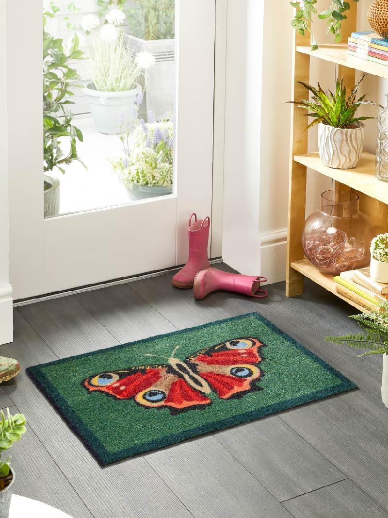 Green butterfly doormat at back door from My Mat, manufactured by Phoenox Textiles