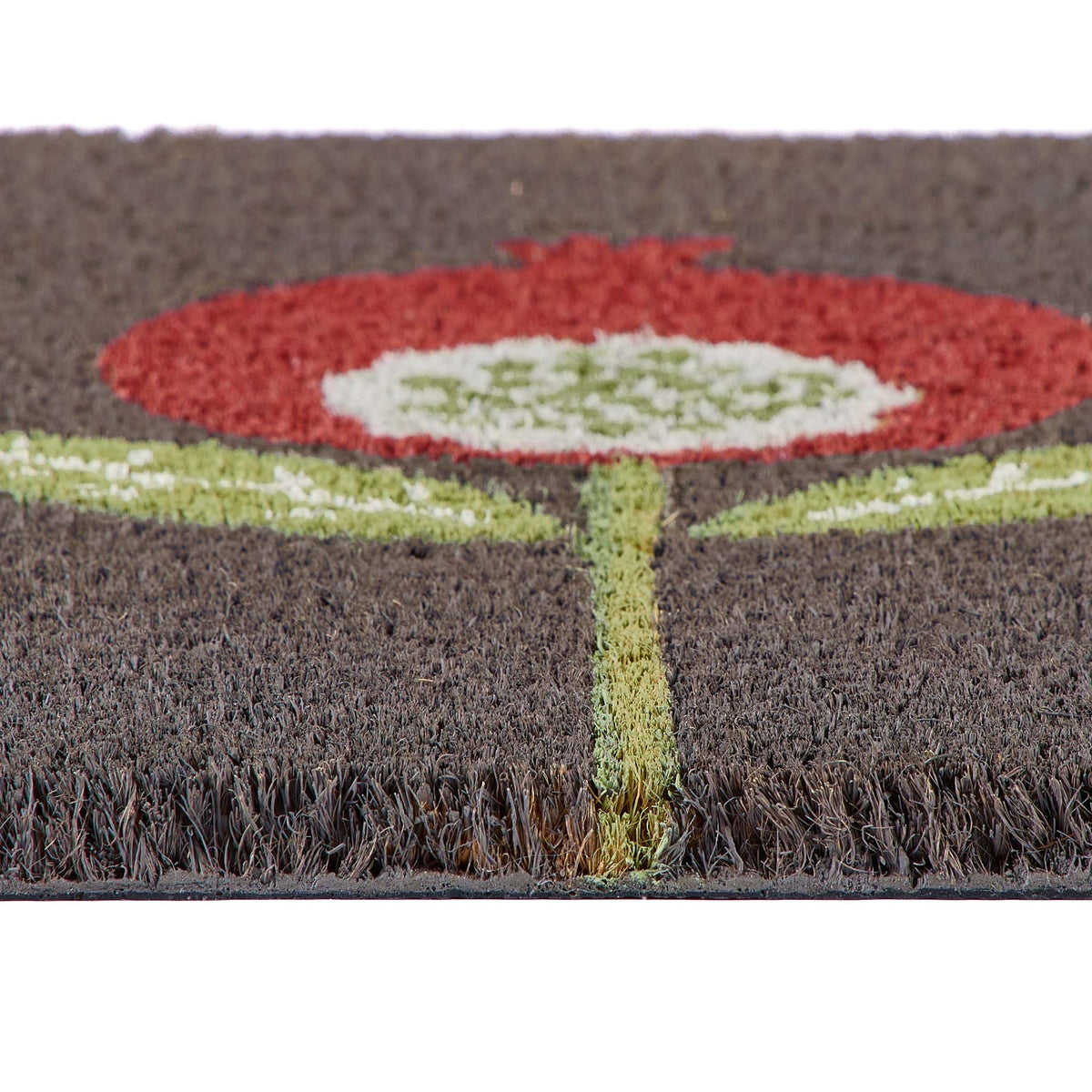 Close-up of a textured doormat with a stylized flower design in red, white, and light green on a dark brown background.