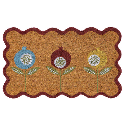 A rectangular coir doormat with a scalloped dark red border and three stylized flower motifs in blue, brown, and yellow on a natural background.