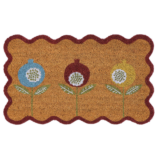 A rectangular coir doormat with a scalloped dark red border and three stylized flower motifs in blue, brown, and yellow on a natural background.