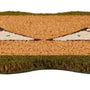 A close-up of a textured doormat with a tan and brown animal face design, featuring green borders at the top and bottom, set against a plain white background.