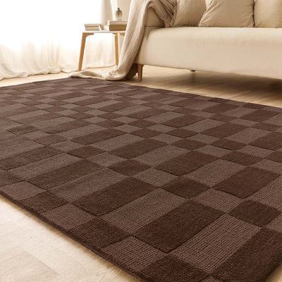 A rectangular area rug with a dark brown and medium brown checkerboard pattern, shown in a brightly lit living room setting with a sofa and side table in the background.