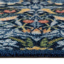 Close-up of a textured outdoor doormat with a symmetrical floral pattern in navy blue, light blue, yellow, and coral pink.