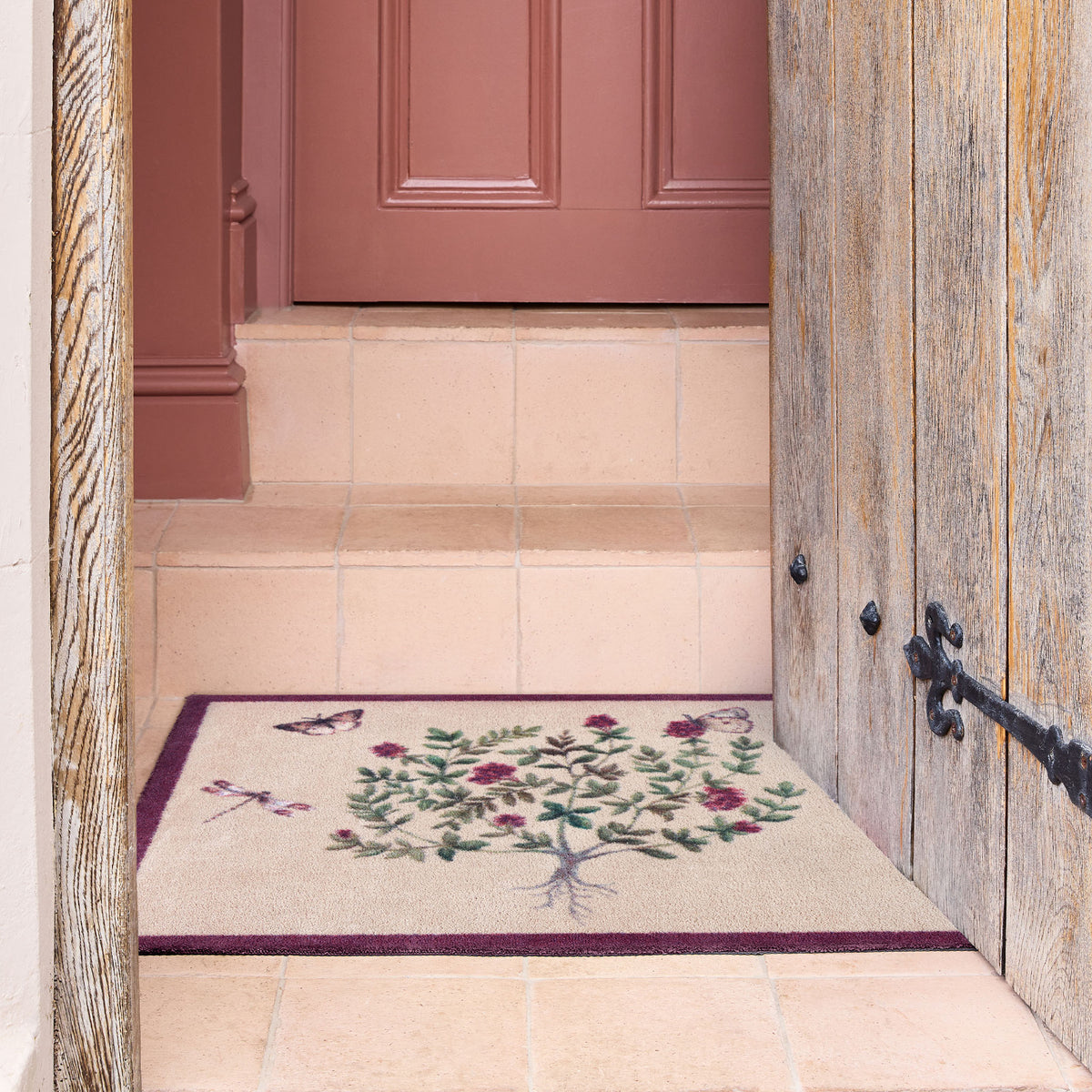 Sanderson By Highgrove x Hug Rug Thyme Walk Damson & Quince with a floral design, styled on tile flooring.