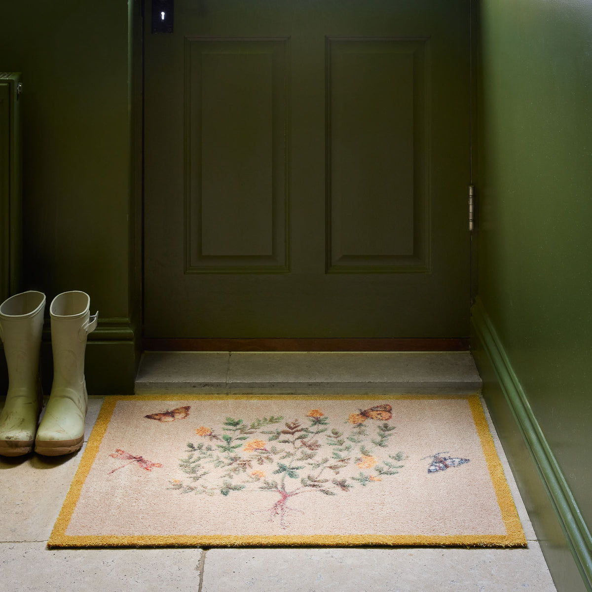 Sanderson By Highgrove x Hug Rug Thyme Walk Lichen & Gooseberry with a floral yellow design, styled by a green door. 