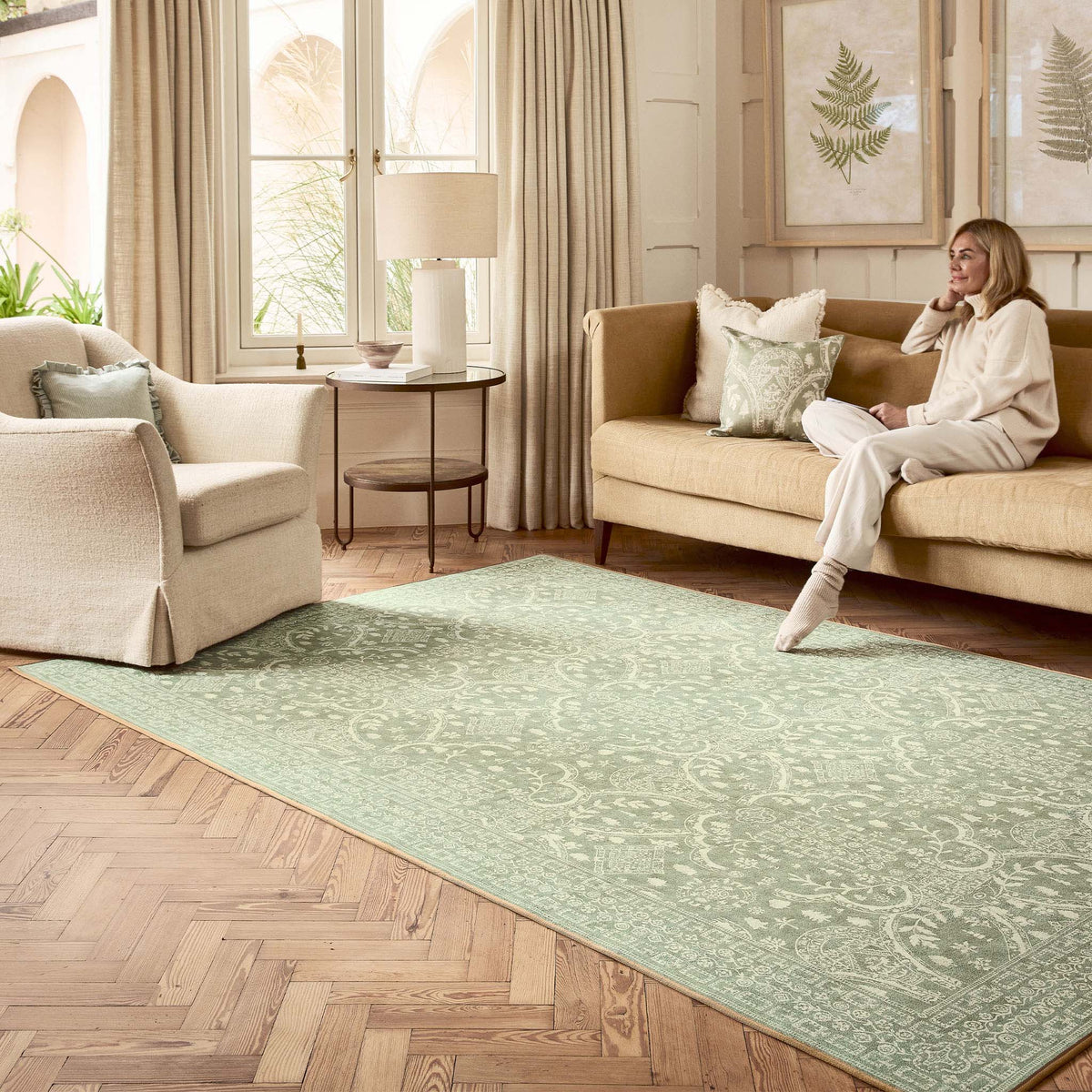 Sanderson By Highgrove x Hug Rug Eco-Washable Topiary View Thyme Rug in green with a traditional style pattern, styled in a living room. 