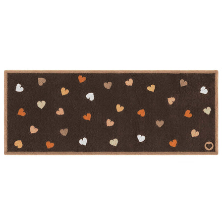 A rectangular brown mat with a border and scattered heart motifs in orange, beige, white, and brown, shown on a plain white background.