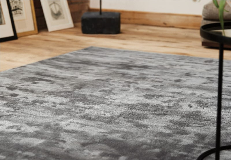 a large, soft grey rug on a living room floor