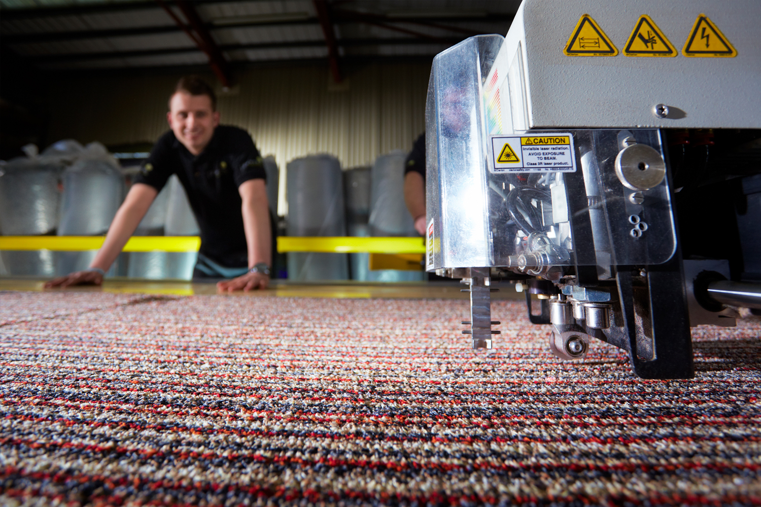 Cutting carpet with man in background out of focus